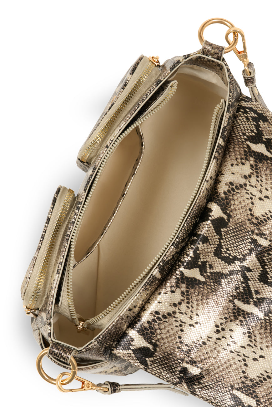 Intérieur du sac bandoulière Pie python, multiples poches zippées et doublure beige.