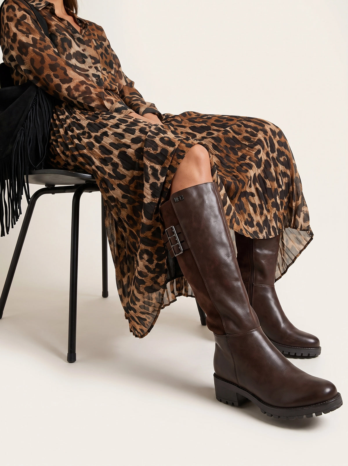 Botte Pandora marron portée assise avec une robe imprimé léopard