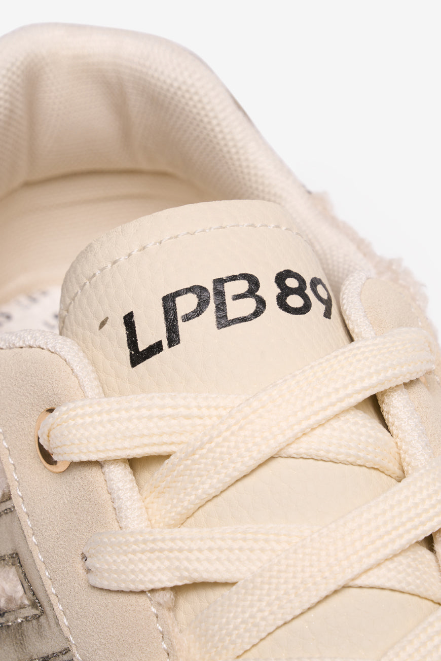 Gros plan sur la languette dorée LPB89 de la basket 89 Sherpa Maelle beige