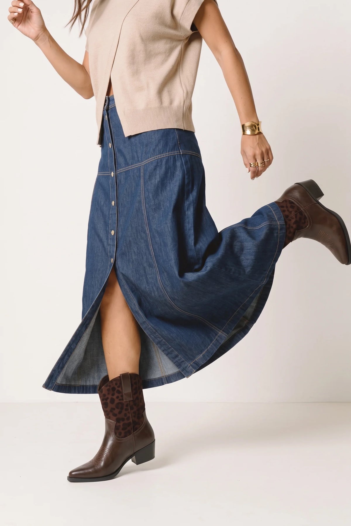 Bottines Phoebe choco léo portées avec une jupe en jean fendue, tige façon léopard.