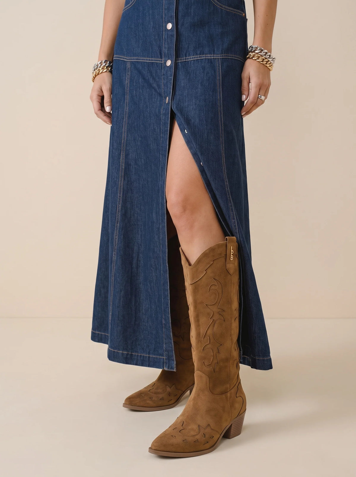 Bottes Pia camel portées avec une robe en jean boutonnée fendue, tige haute façon western.
