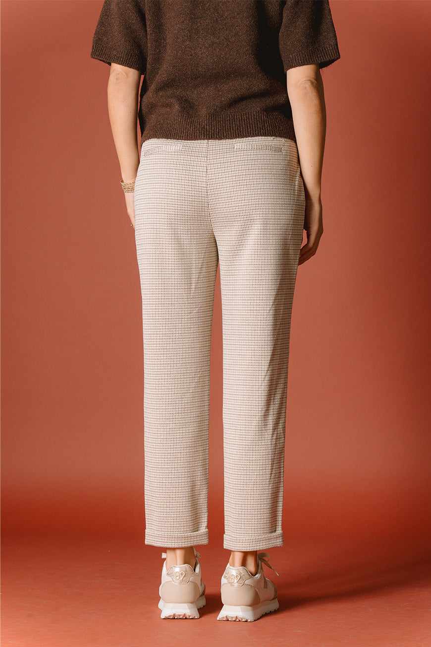Pantalon Cassendra imprimé Islay beige à pinces et revers, vue de dos, porté avec des baskets beige.