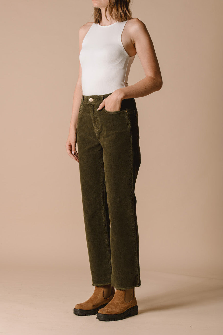 Pantalon Paulina kaki en velours côtelé vue de profil, porté avec un débardeur blanc.