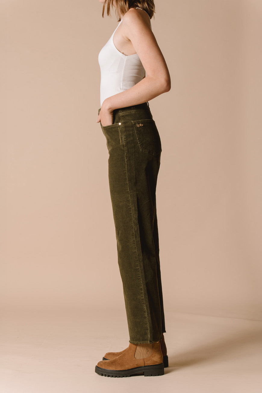 Pantalon Paulina kaki en velours côtelé vue de profil, porté avec des bottines camel.