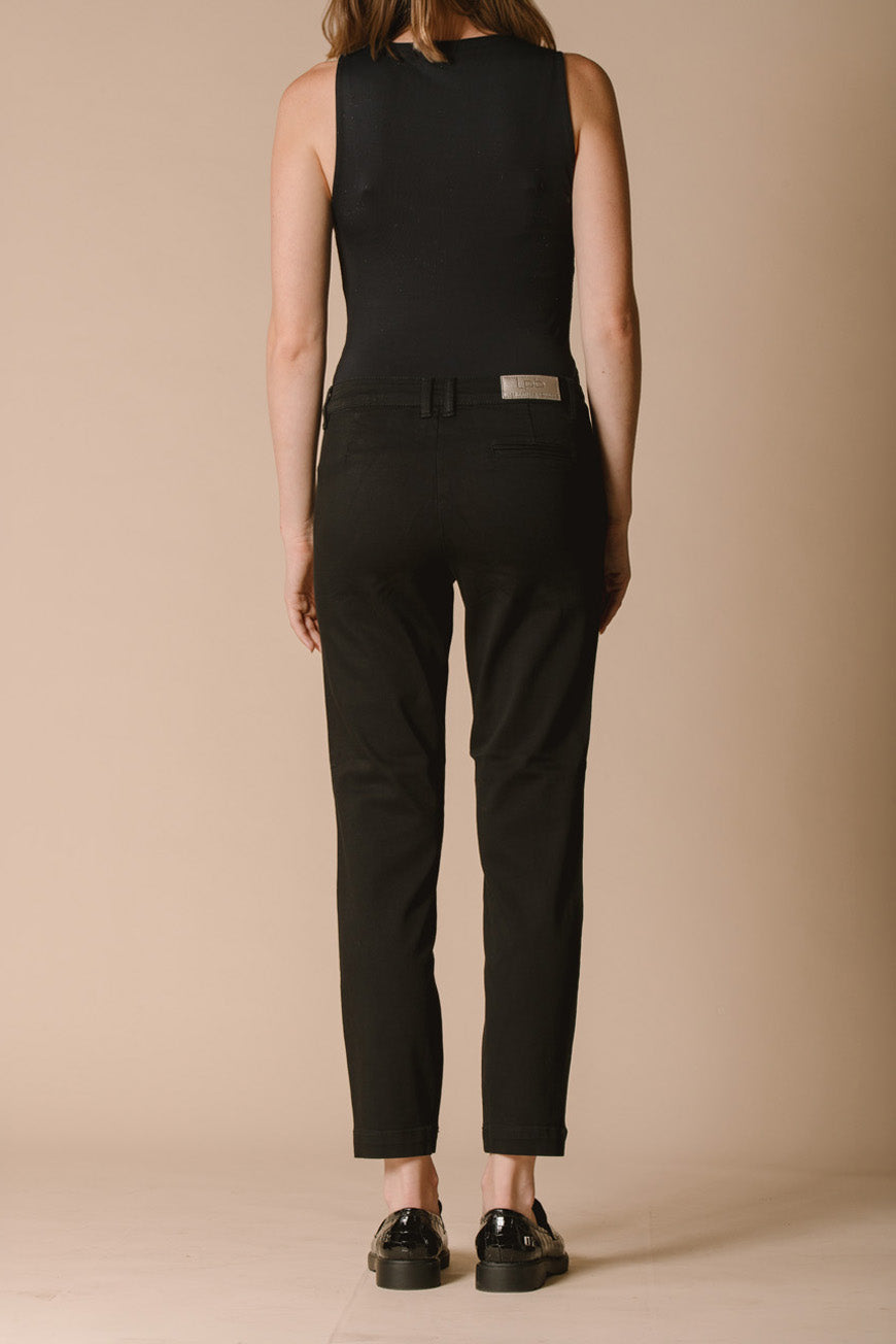 Pantalon chino Naomie noir vue de dos, porté avec un débardeur noir et des mocassins vernis.
