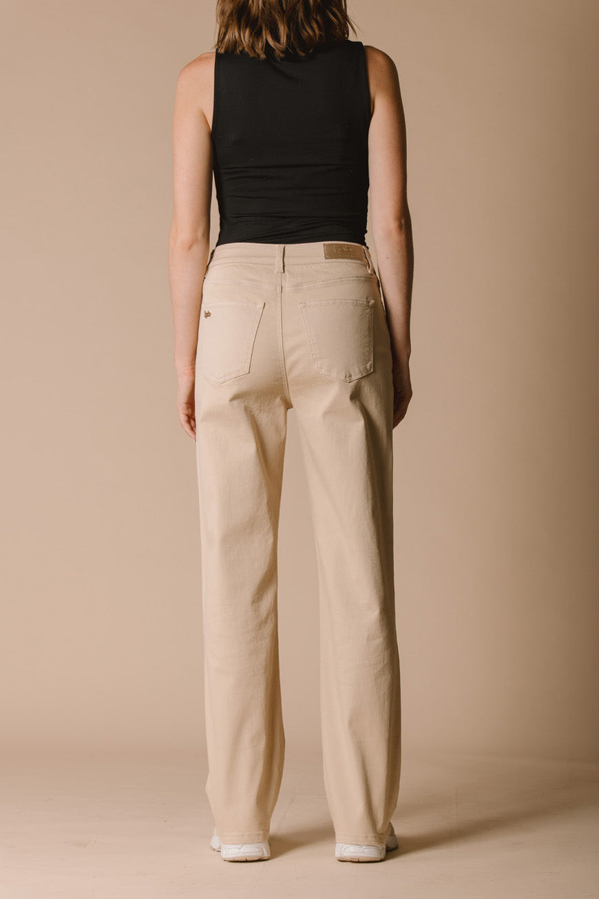 Pantalon Paola beige droit vue de dos, porté avec des baskets blanches.