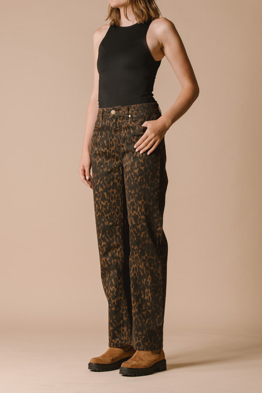 Pantalon Paola imprimé léopard porté de trois-quarts, main dans la poche