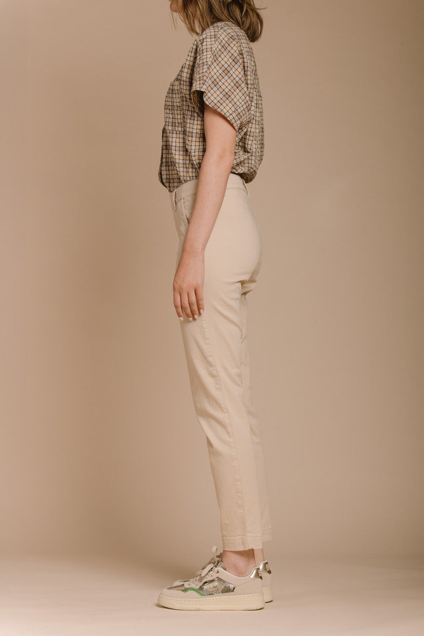 Pantalon Naomie beige slim vue de profil, porté avec des baskets à semelle beige.