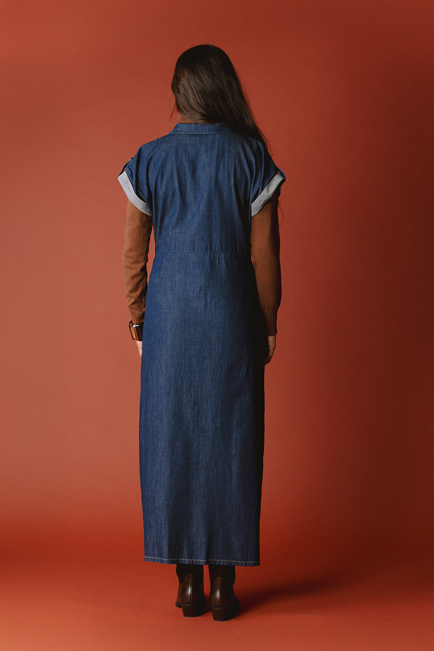 Robe Nassina longue en jean brut vue de dos, portée avec un pull marron à col roulé.