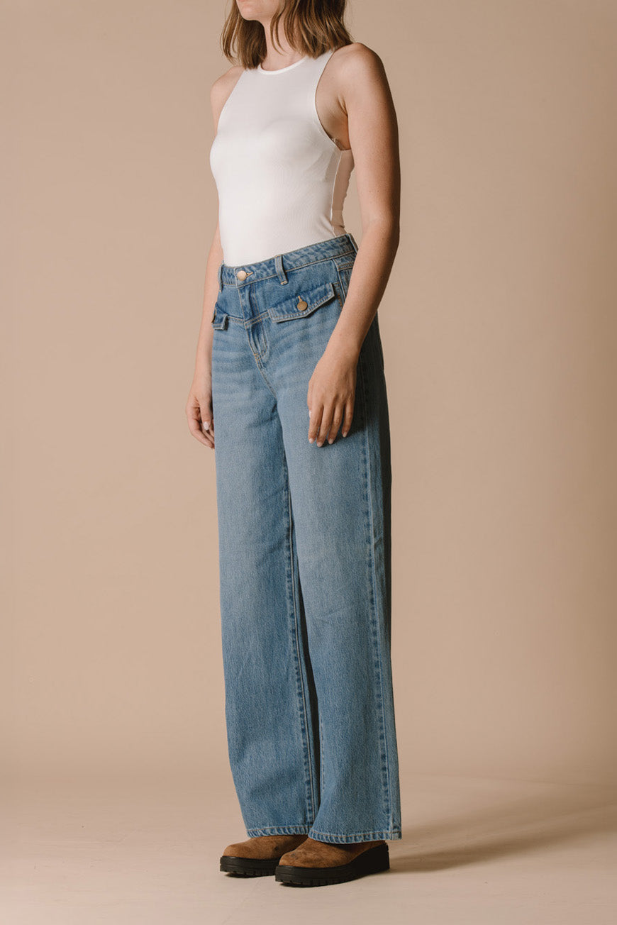 Pantalon Prew bleu large vue de profil, porté avec un débardeur blanc et des bottines camel.