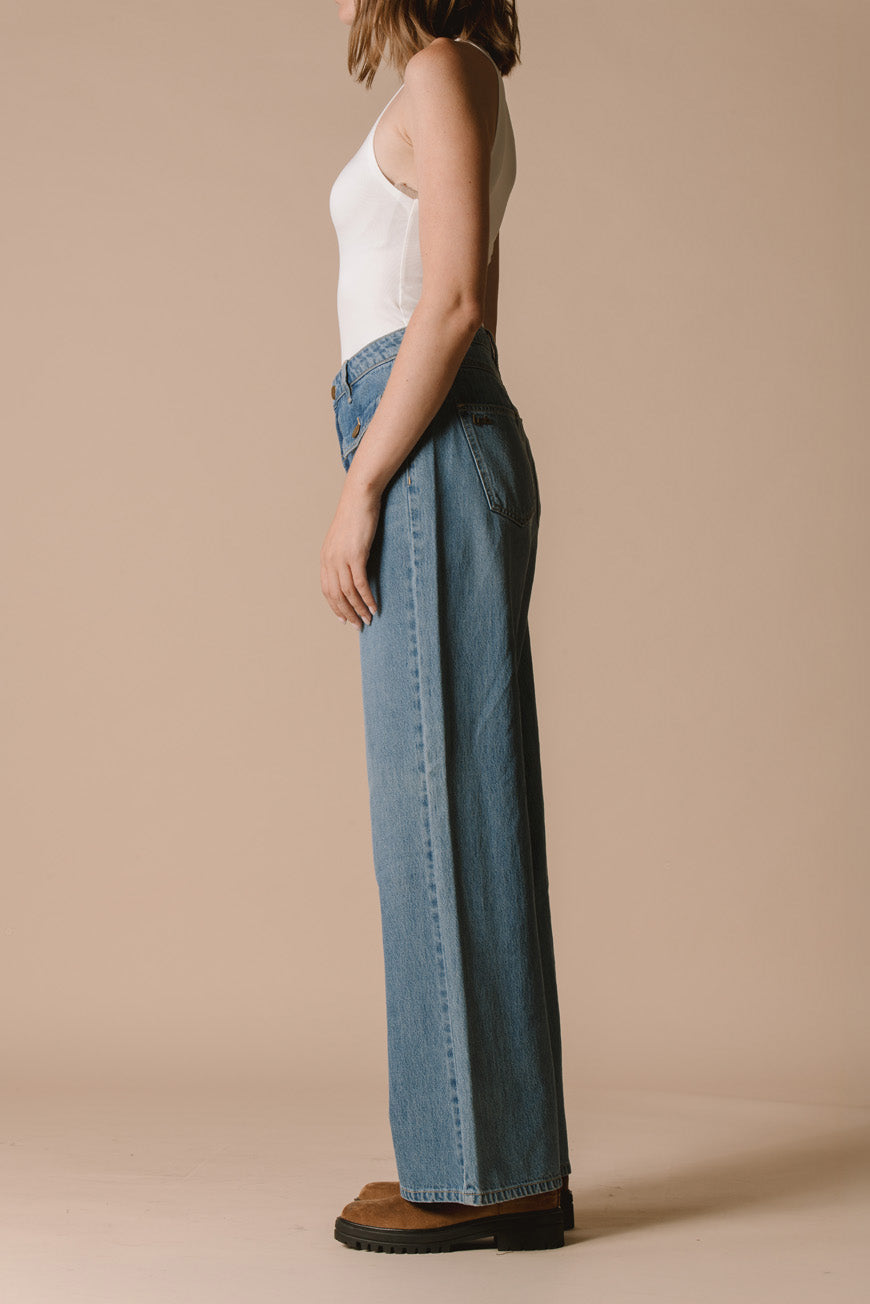 Pantalon Prew bleu large vue de profil, porté avec des bottines camel.