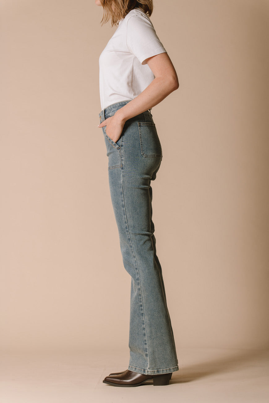 Jean Janis bootcut relax vue de profil, porté avec des santiags marron.