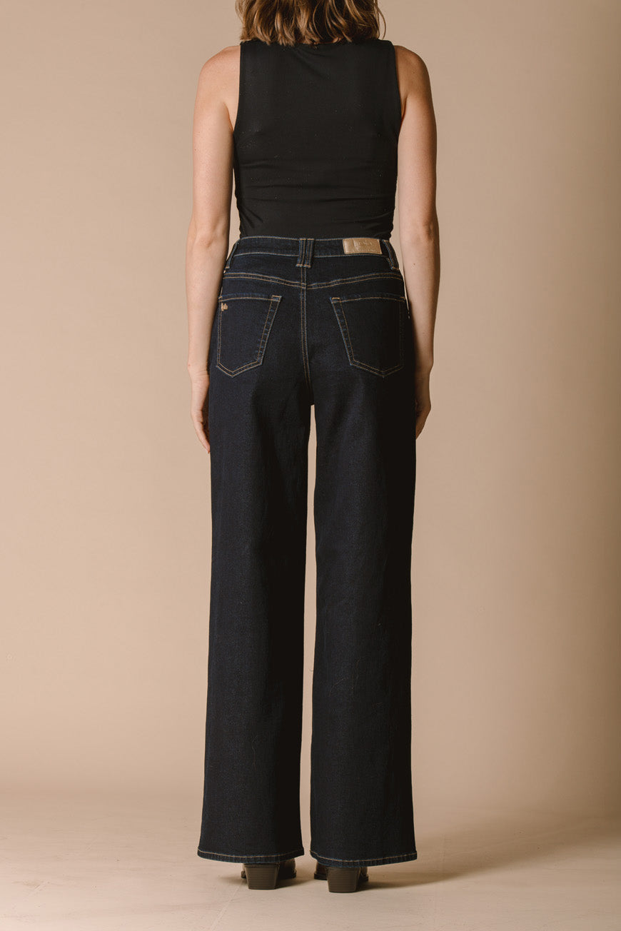 Pantalon Jonah brut bleu foncé large vue de dos, porté avec des bottines marron.