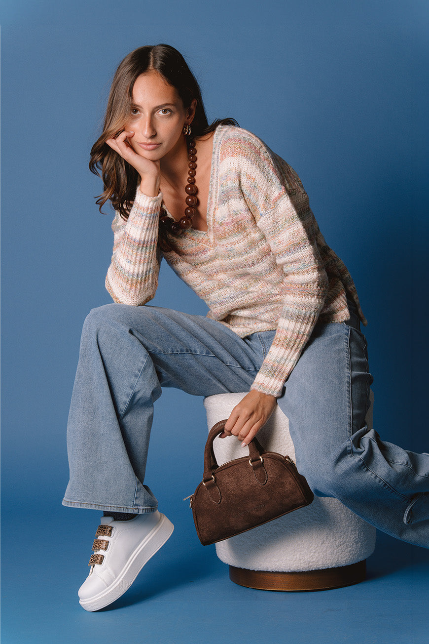 Pull Manuel à rayures multicolores, porté assis avec un sac à main marron