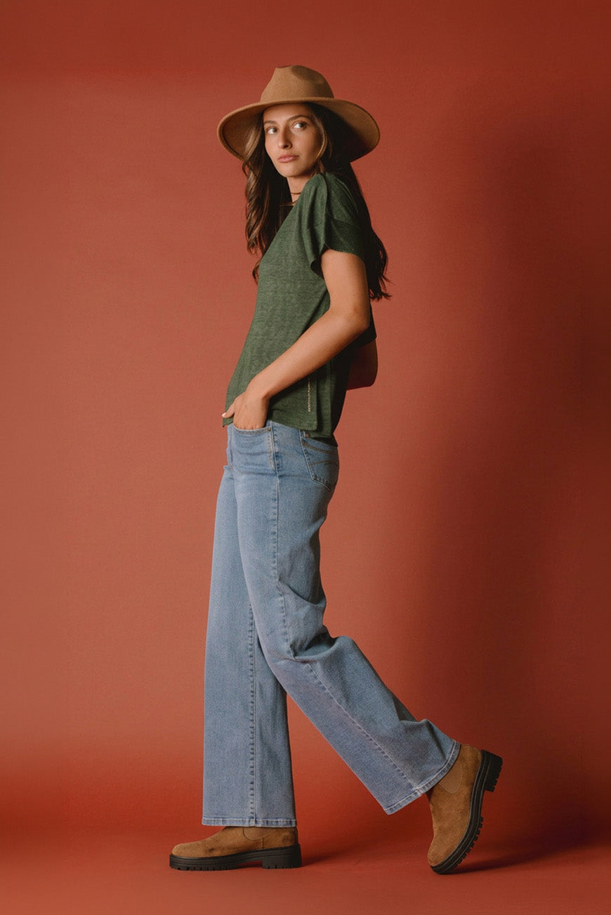 Tee-shirt Naline kaki col V porté de profil avec un jean large clair
