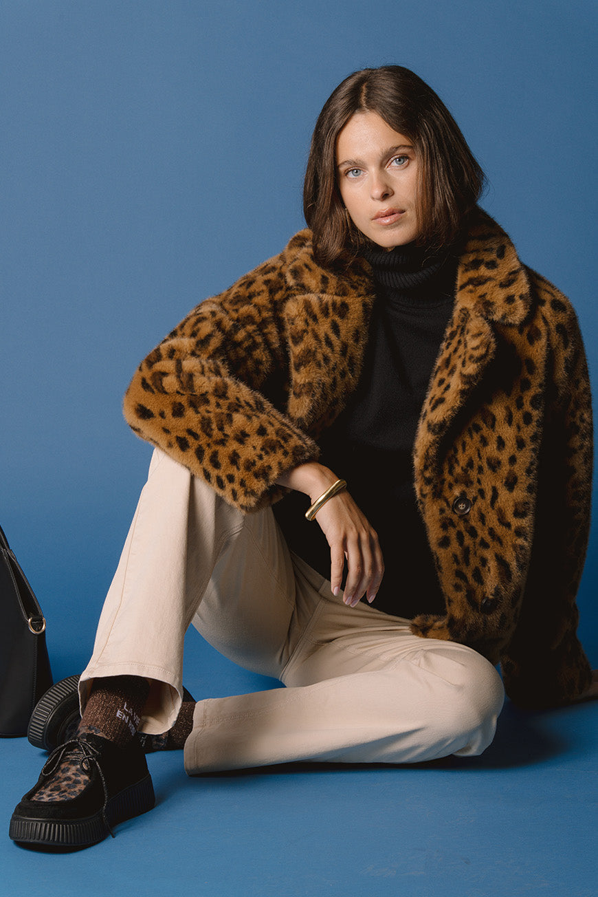 Manteau Piat imprimé léopard, porté assise avec des sneakers façon creepers